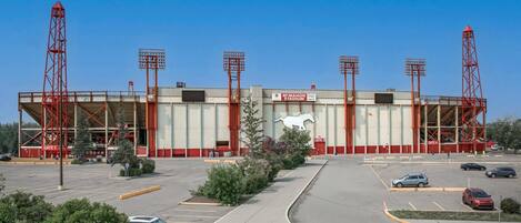 A large stadium with multiple gates and a parking lot.