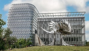 Un edifici modern amb una escultura metàl·lica única al davant.