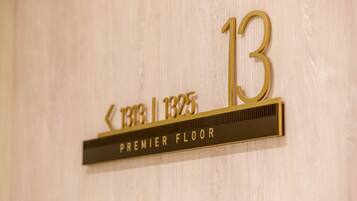 Un letrero dorado con el número 13 y debajo la inscripción 'PREMIER FLOOR'.