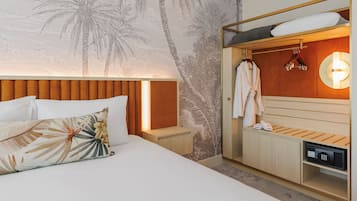 Una habitación de hotel con cama, mesita de noche, armario de madera, bata y zapatero.