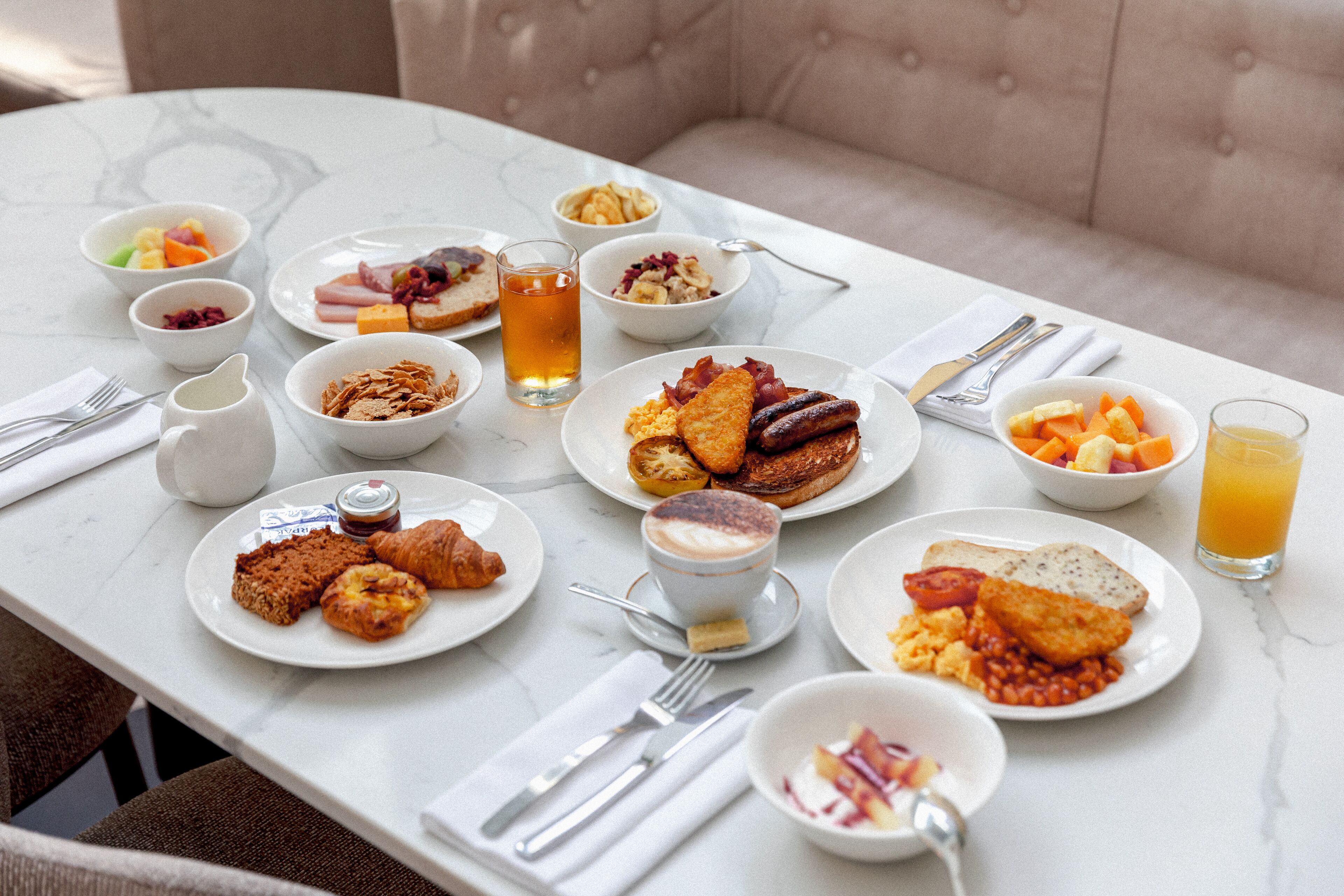 Een ontbijttafel met diverse gerechten, zoals toast, eieren en fruit.
