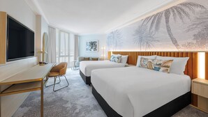 A hotel room with two beds, a desk, a TV, and a large wall mural. - Amora Hotel Brisbane (Spring Hill)