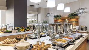 A buffet setup with various food items, including bread, fruits, and a salad bar. - Amora Hotel Brisbane (Spring Hill)