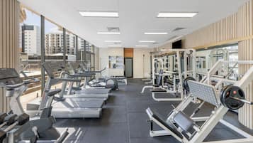 A gym with treadmills, weight machines, and a mirror.