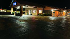 A Royal Inn & Suites building with a 'Low Clearance' sign, a brick facade, and a parking lot at night. - Royal Inn & Suites (Mountain Grove)