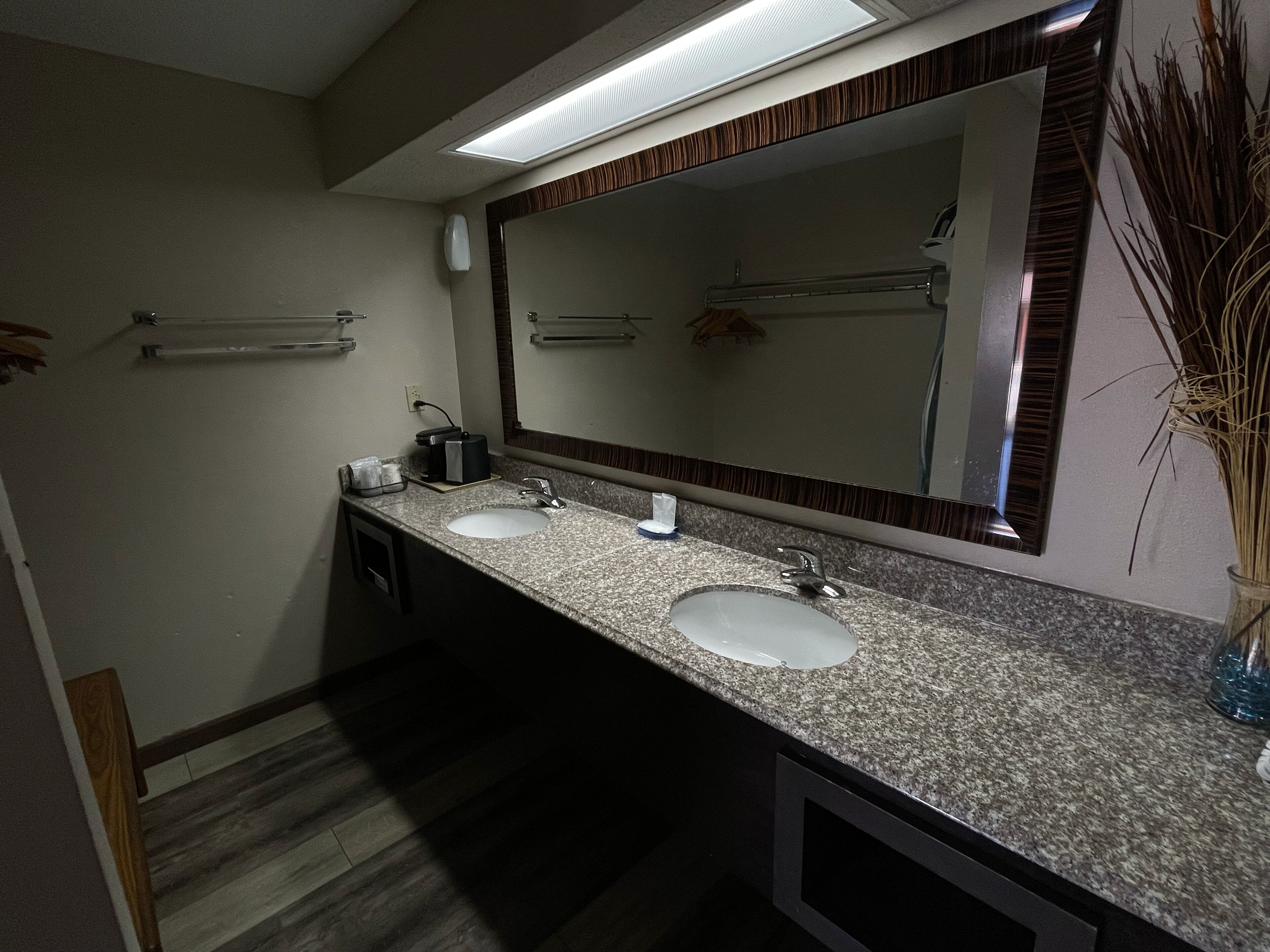 Un baño con dos lavamanos, un espejo y un toallero.