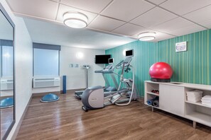 A fitness room with treadmills, a stationary bike, a rowing machine, a red exercise ball, and a wall-mounted TV. - Holiday Inn Express Ramsey-Mahwah by IHG (Ramsey)