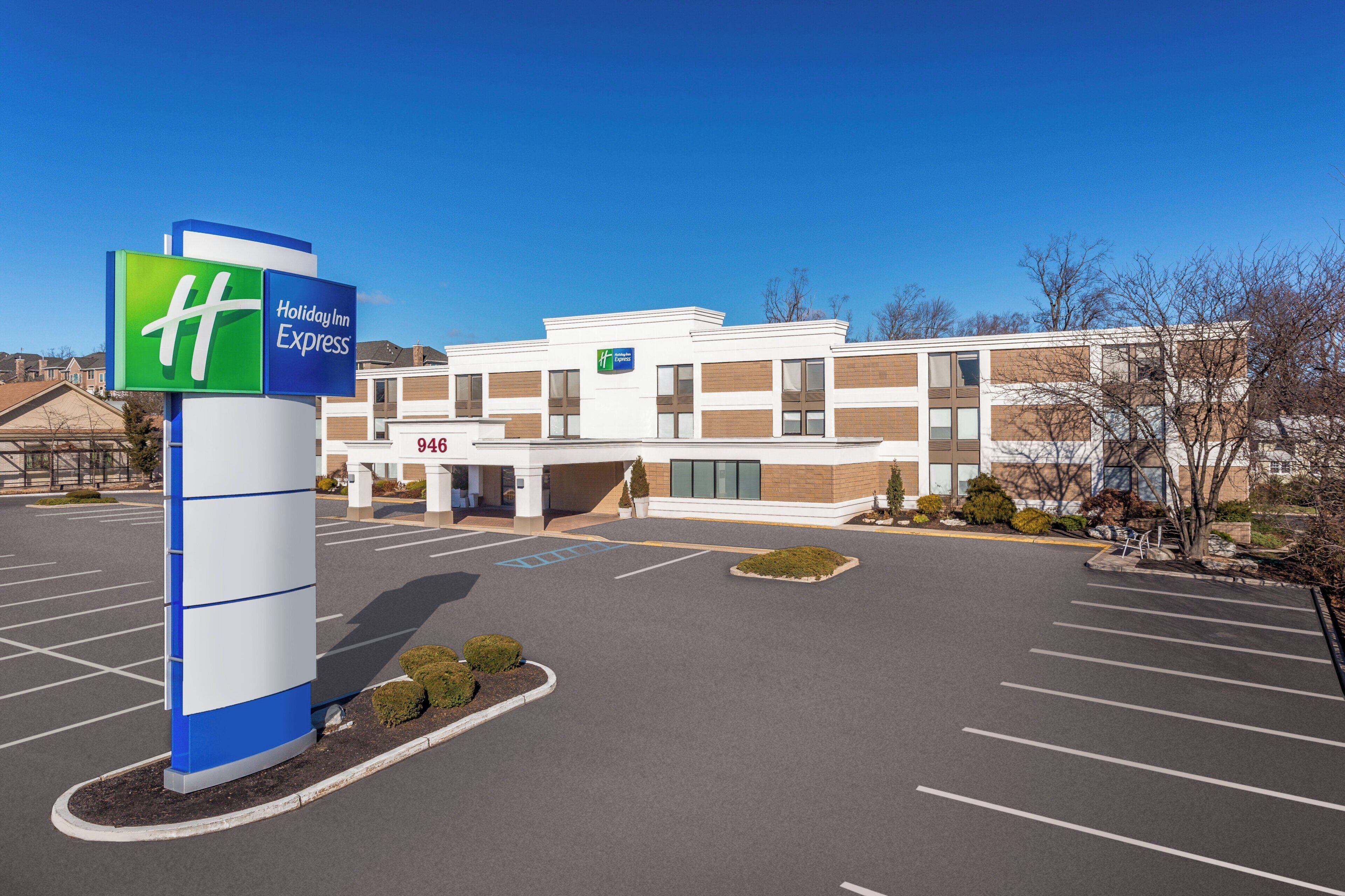A Holiday Inn Express building with a parking lot and a clear blue sky.