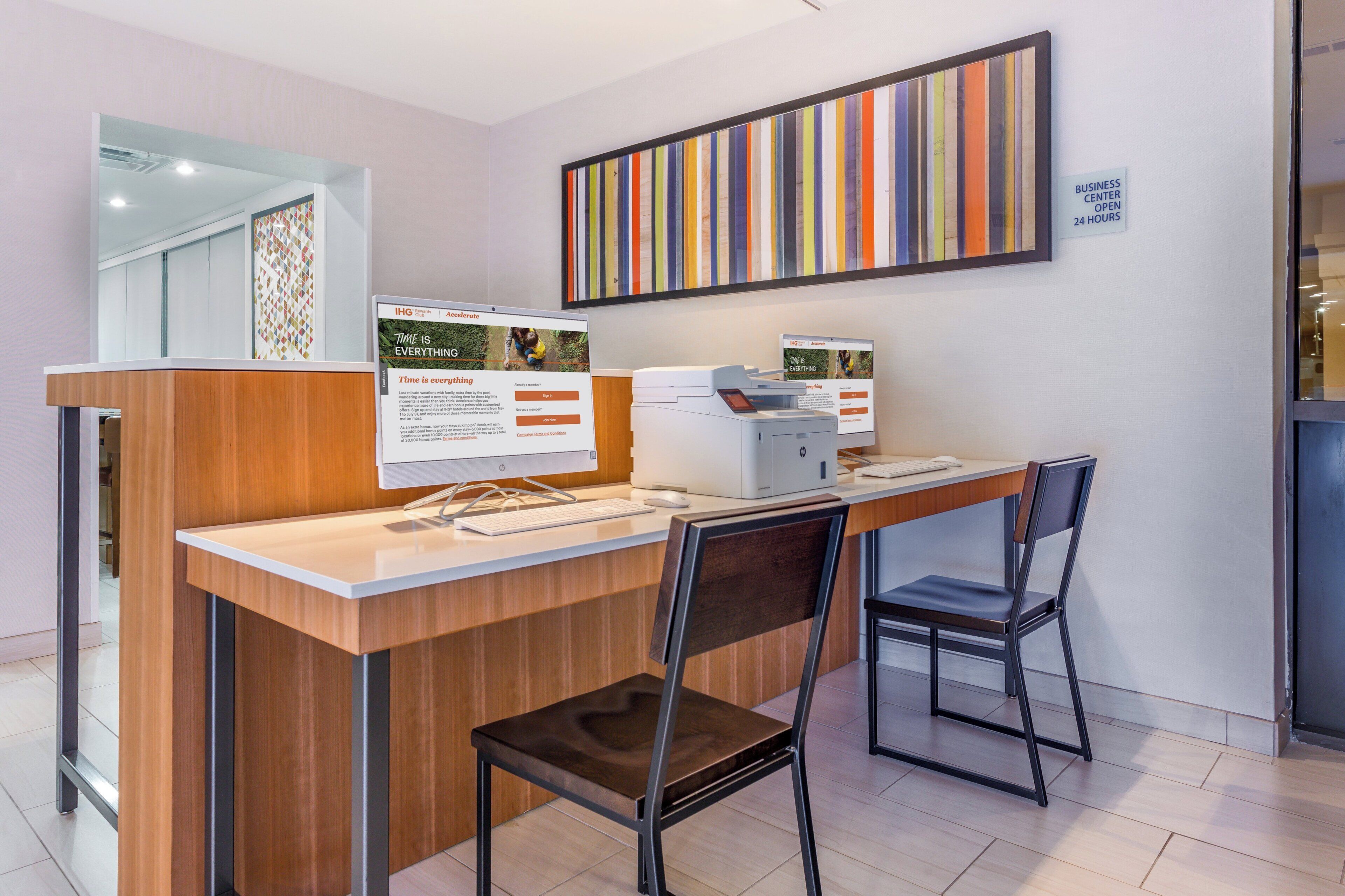 A reception desk with a computer, a chair, and a signboard.
