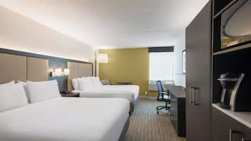 Une chambre d’hôtel avec deux lits, un bureau, une chaise, un minibar et une fenêtre.