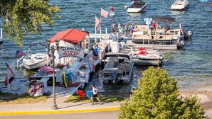 Un port de plaisance avec des bateaux amarrés, un service de location de bateaux et un petit restaurant situé au bord du quai.