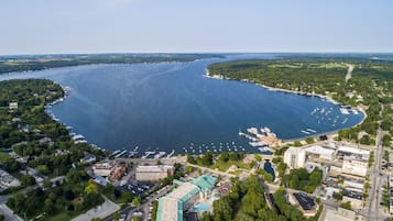 An aerial view of a coastal town with a marina, buildings, and roads.