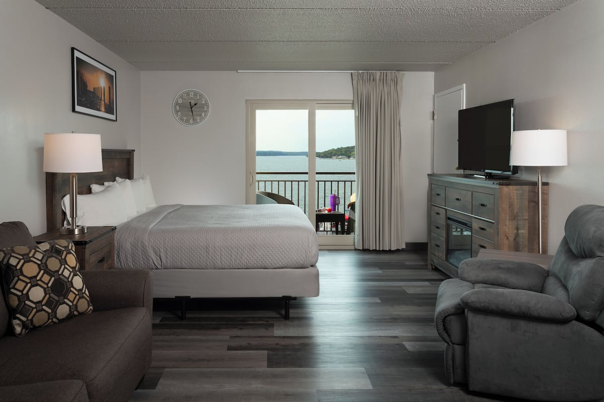 Une chambre d’hôtel avec un lit, une télévision, un canapé et une vue sur la mer.