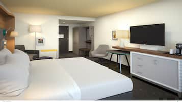 Habitación de hotel con una cama grande, un escritorio con televisor de pantalla plana, una silla, una mesita y un armario.