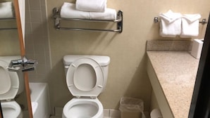 Une petite salle de bain comprenant des toilettes, un lavabo et un porte-serviettes.