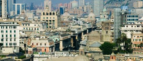 Un paisaje urbano con una mezcla de edificios históricos y modernos, incluyendo una imponente torre del reloj y una gran estructura abovedada.