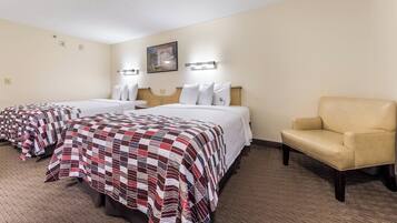 A hotel room with two beds, a chair, and a painting on the wall.