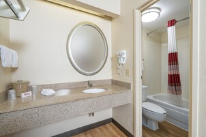 Bañera con ducha, toallas, jabón, shampoo
