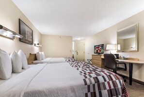 Une chambre d’hôtel avec deux lits, un bureau, une chaise, une télévision et un tableau au mur.