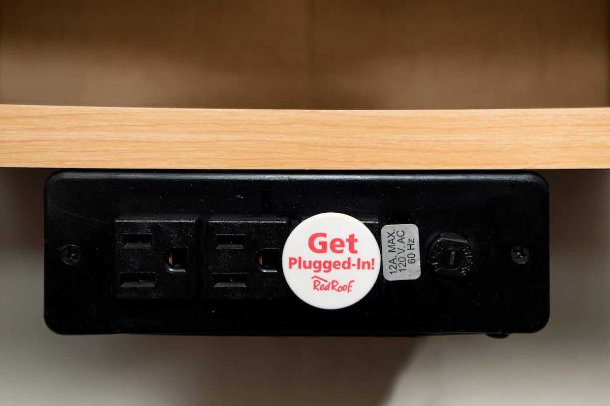 A power strip with a "Get Plugged-In!" badge and a label indicating "120V AC 60 Hz".