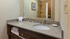 A bathroom with a granite countertop sink, a large mirror, and a towel rack. - Crowne Plaza Columbus North- Worthington by IHG (Columbus)