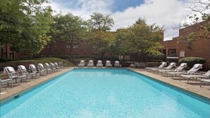 A rectangular swimming pool with clear blue water, surrounded by lounge chairs and trees. - Crowne Plaza Columbus North- Worthington by IHG (Columbus)
