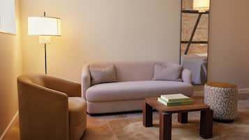 A modern living room with a sofa, armchair, coffee table, and a lamp.