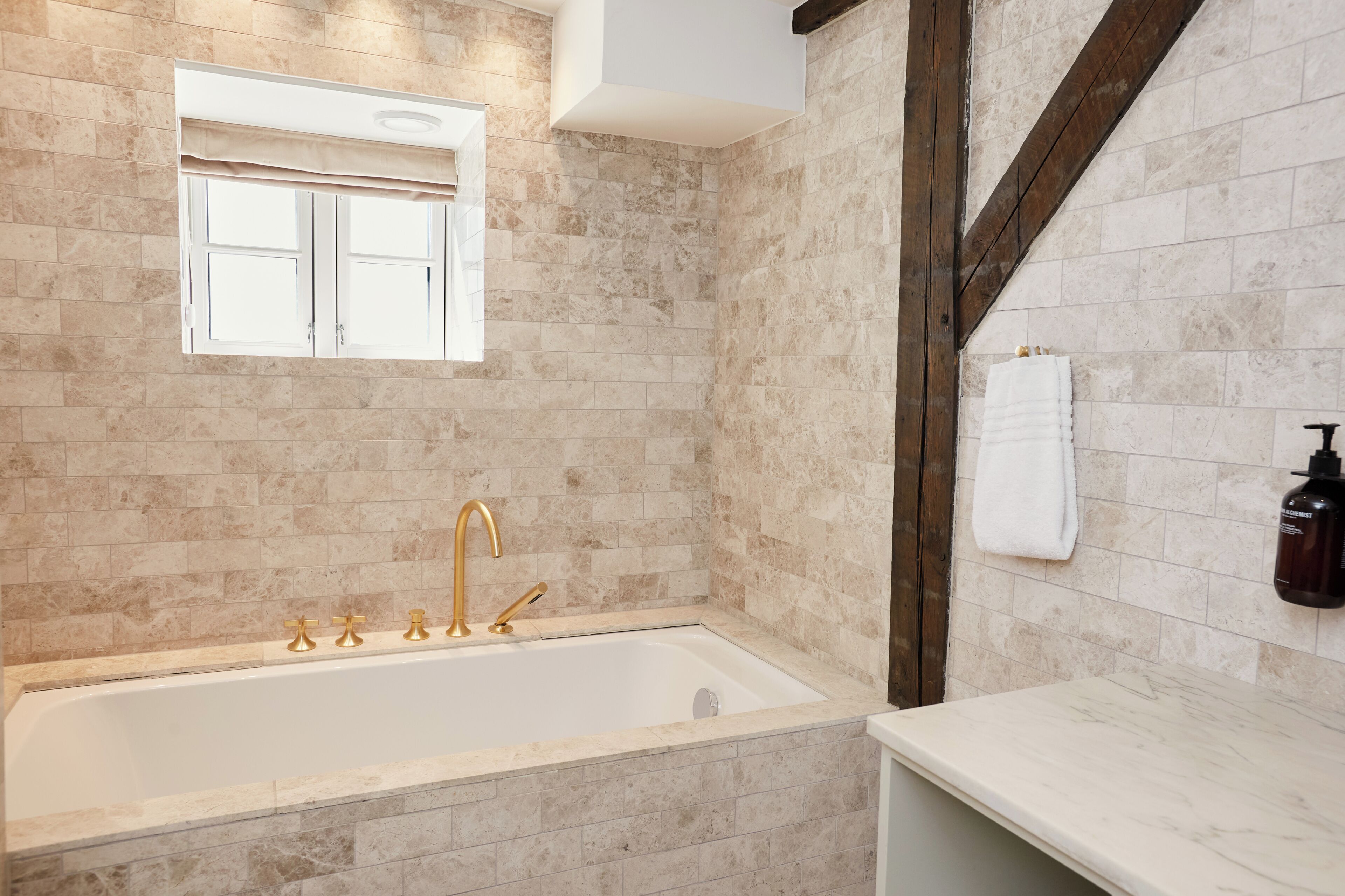 Un baño con bañera, ventana y perchero.