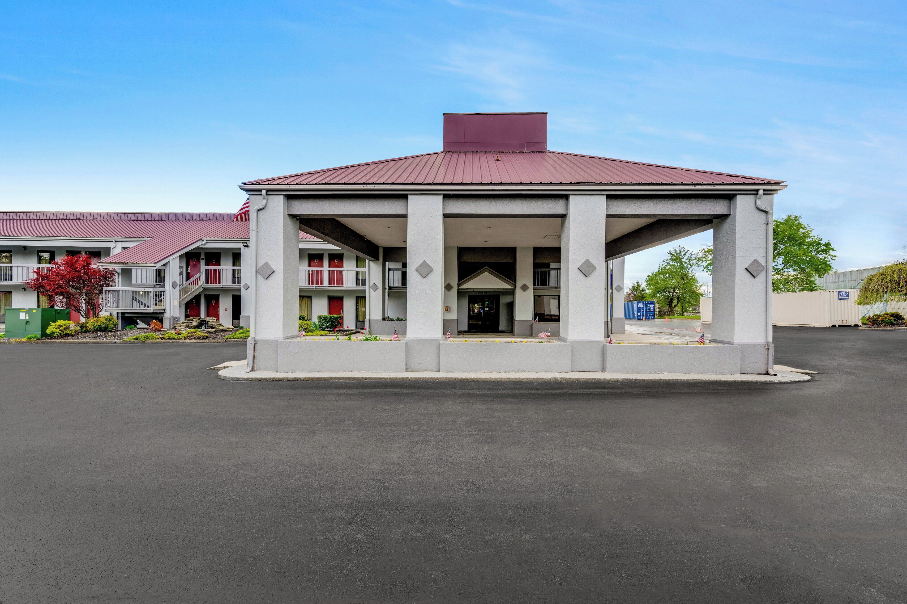 A building with a covered entrance and a red roof.