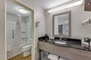 Bañera con ducha, toallas, jabón, shampoo
