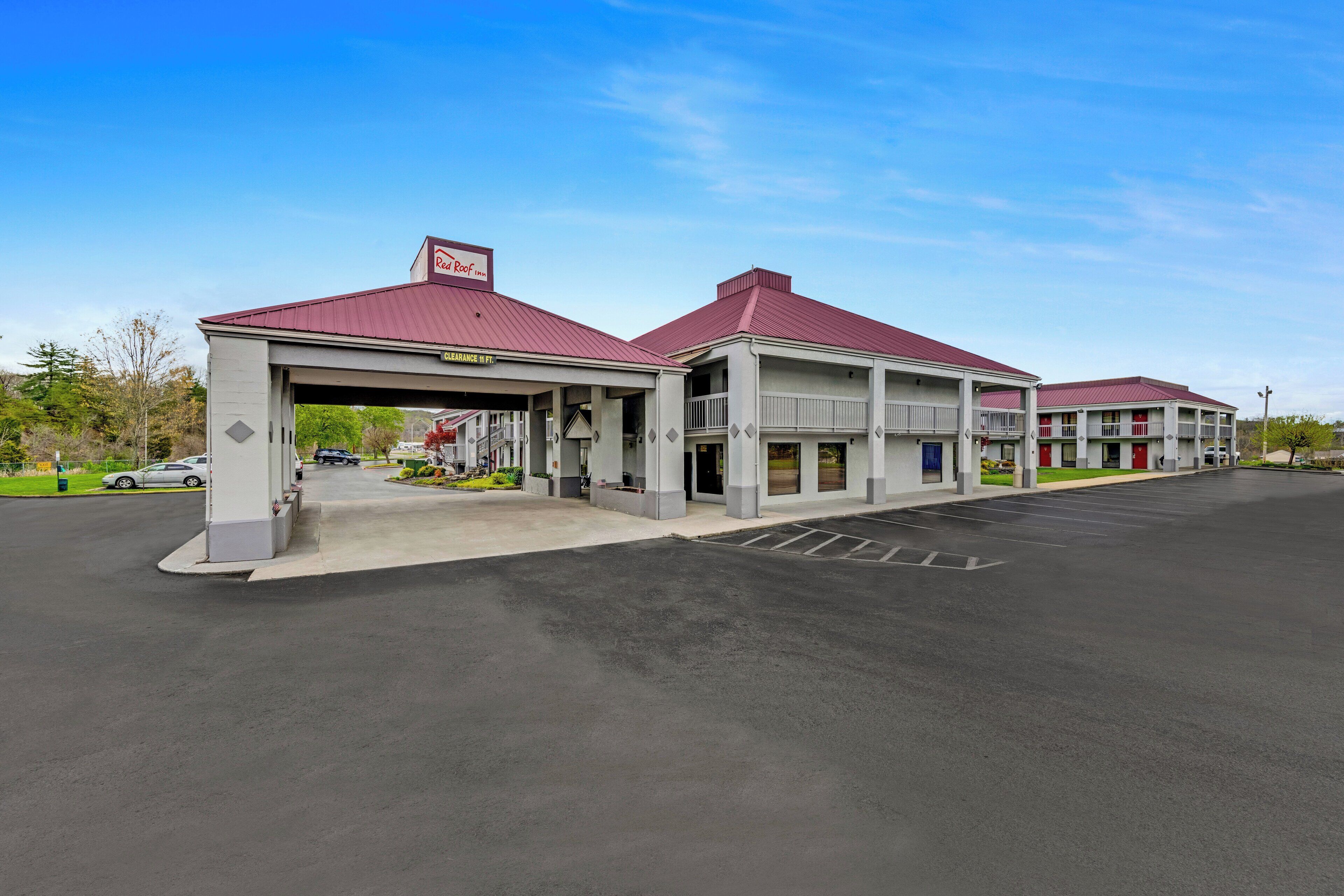 A modern hotel with a red roof and a covered entrance.