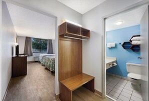 Enjoy a spacious room with a large bed, wooden bench, and wardrobe.