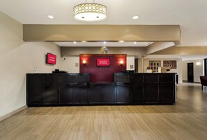 Welcome to our reception area, featuring a central desk with a globe above, surrounded by neutral-toned walls and recessed lighting.