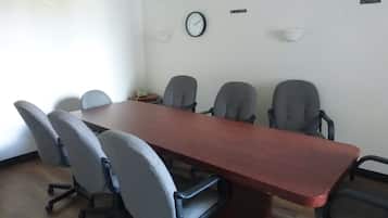 Un salón de conferencias con una larga mesa, seis sillas, un reloj y un cartel que indica 'RIO DE JANEIRO'.