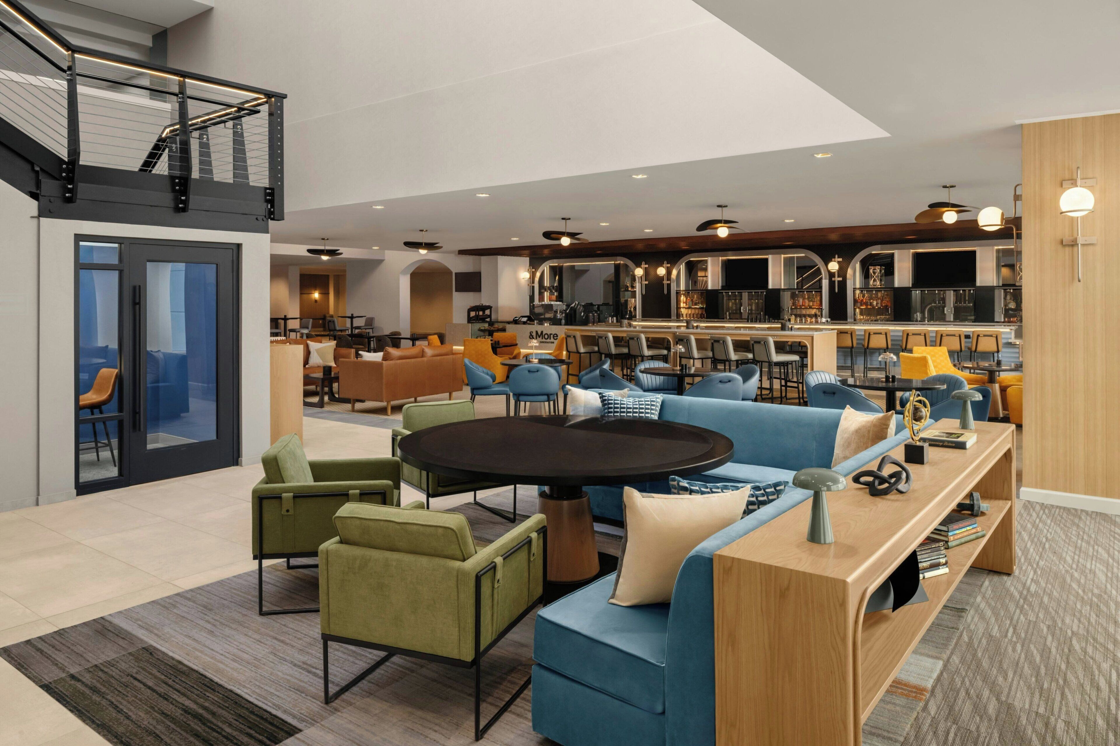 Un interno moderno con una zona salotto centrale, una cucina e un'area bar/lounge.