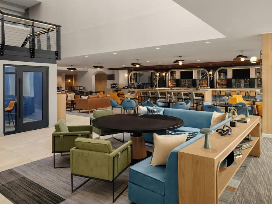 Un interior moderno con una zona de estar central, una cocina y un área de bar o salón.