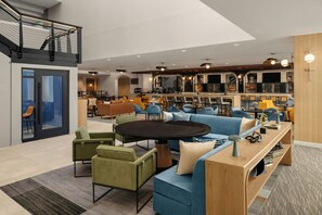A modern interior with a central seating area, a kitchen, and a bar/lounge area. - Sheraton Hartford Hotel at Bradley Airport (Windsor Locks)