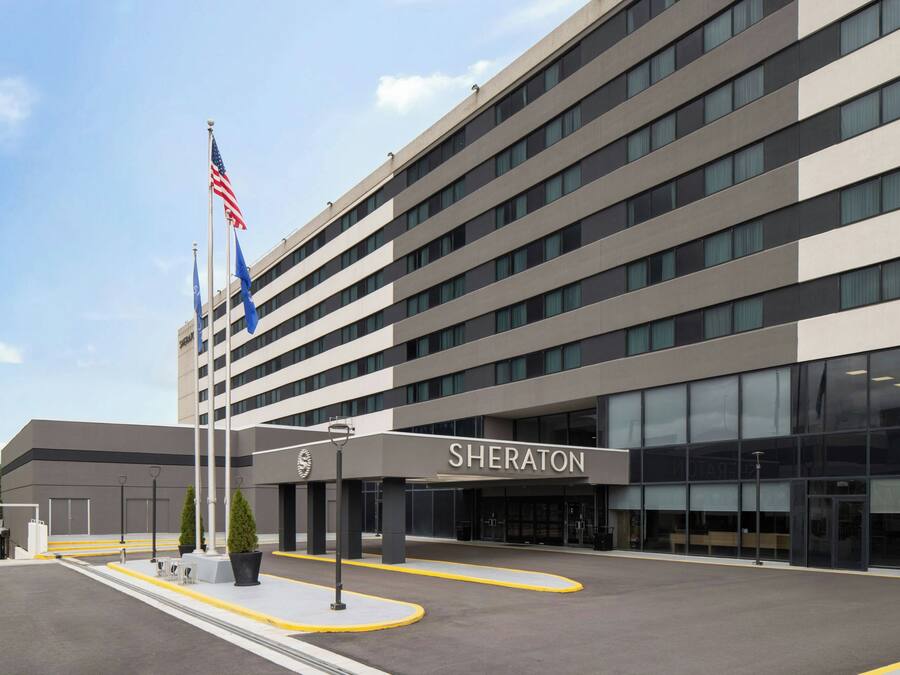 Ein Sheraton Hotel mit moderner Fassade, mehreren Etagen und einem deutlichen Eingang.