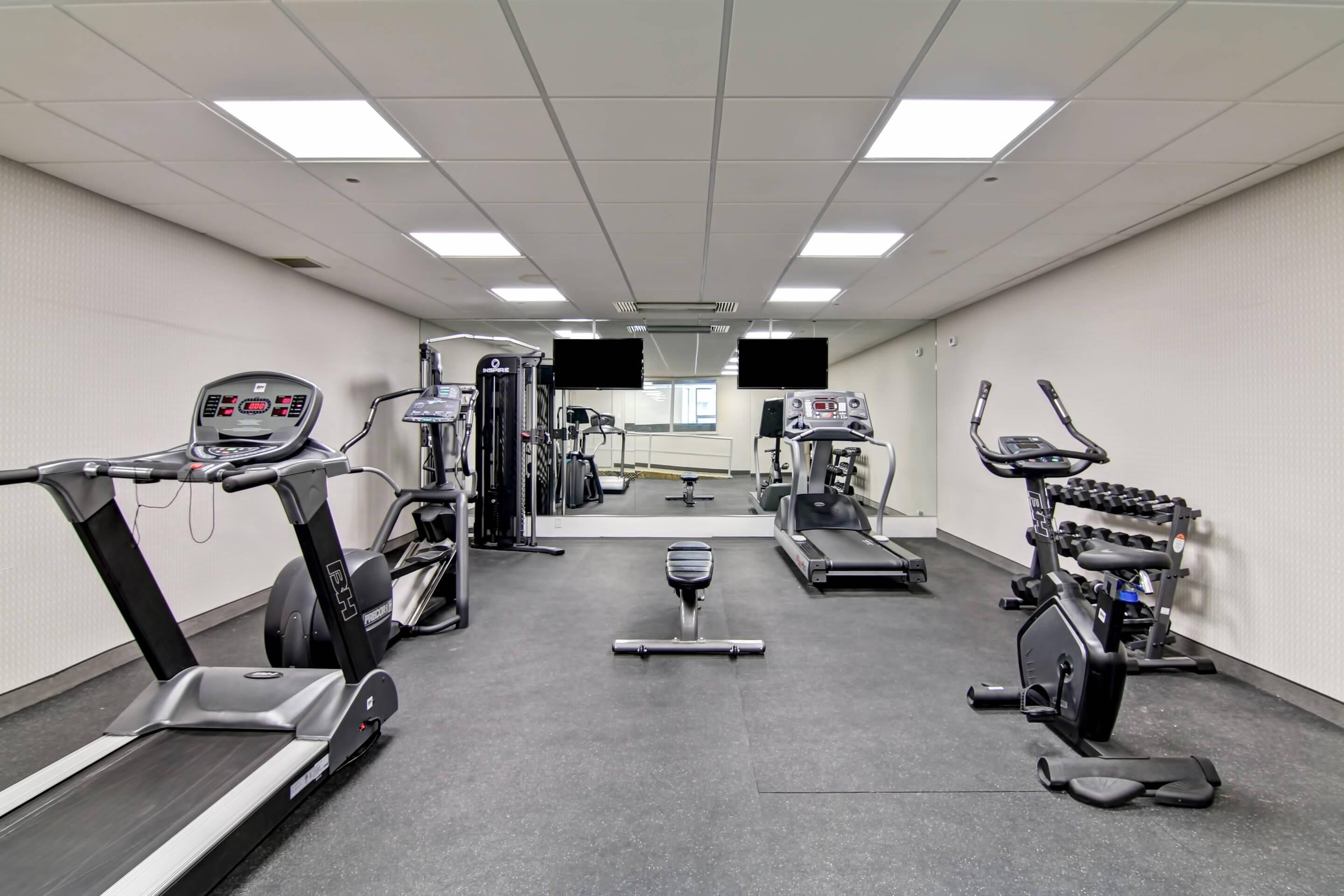 A gym with treadmills, stationary bikes, and weight machines.