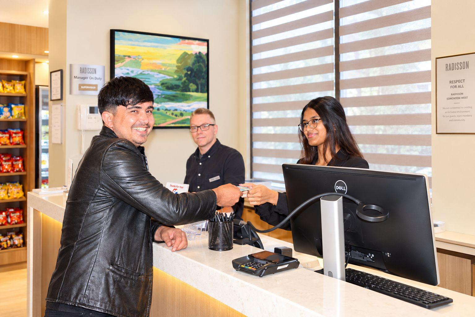 A reception area with a counter, a computer, and a cash register.