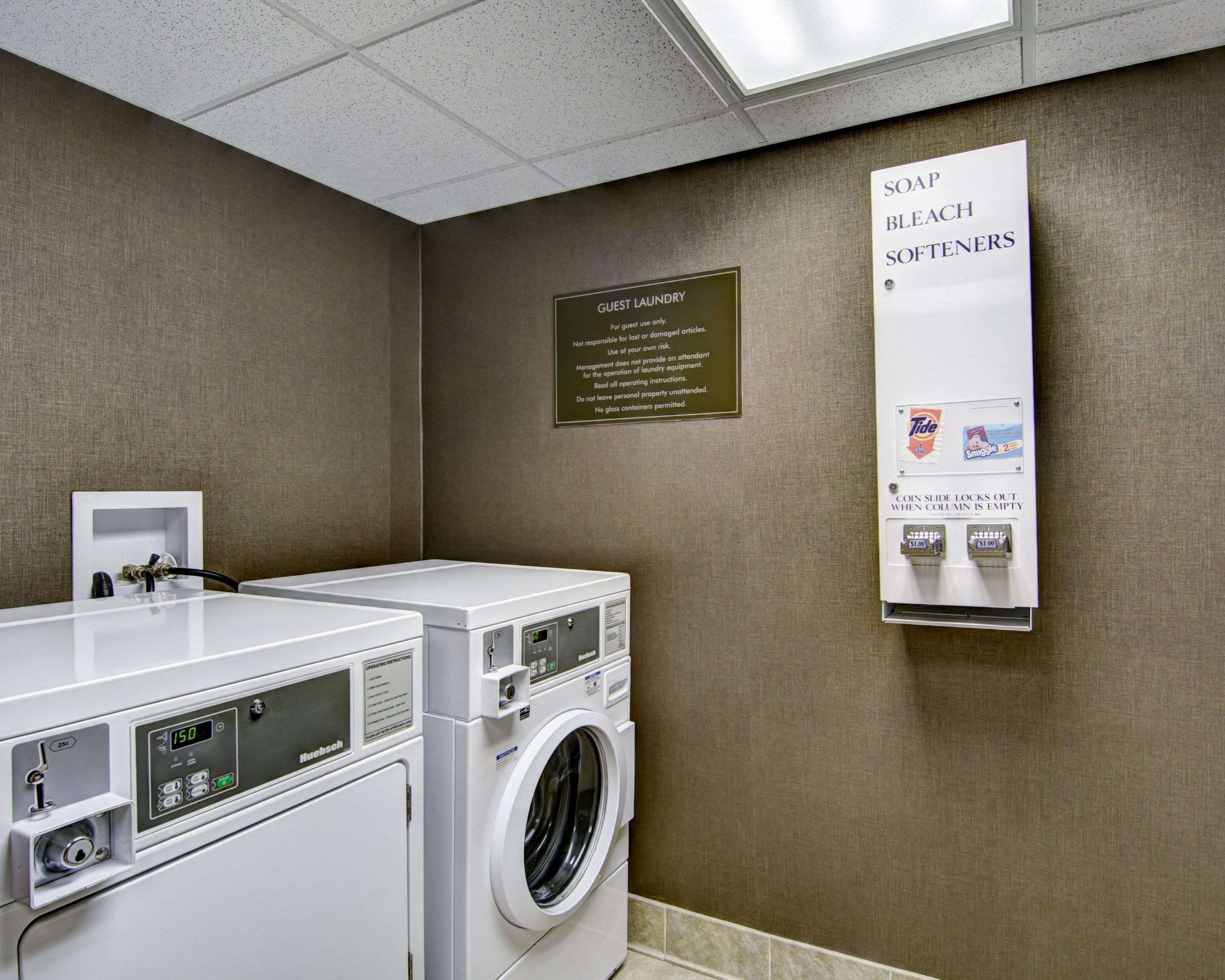 A guest laundry area with a sign indicating the use of Tide and Bounce detergents.