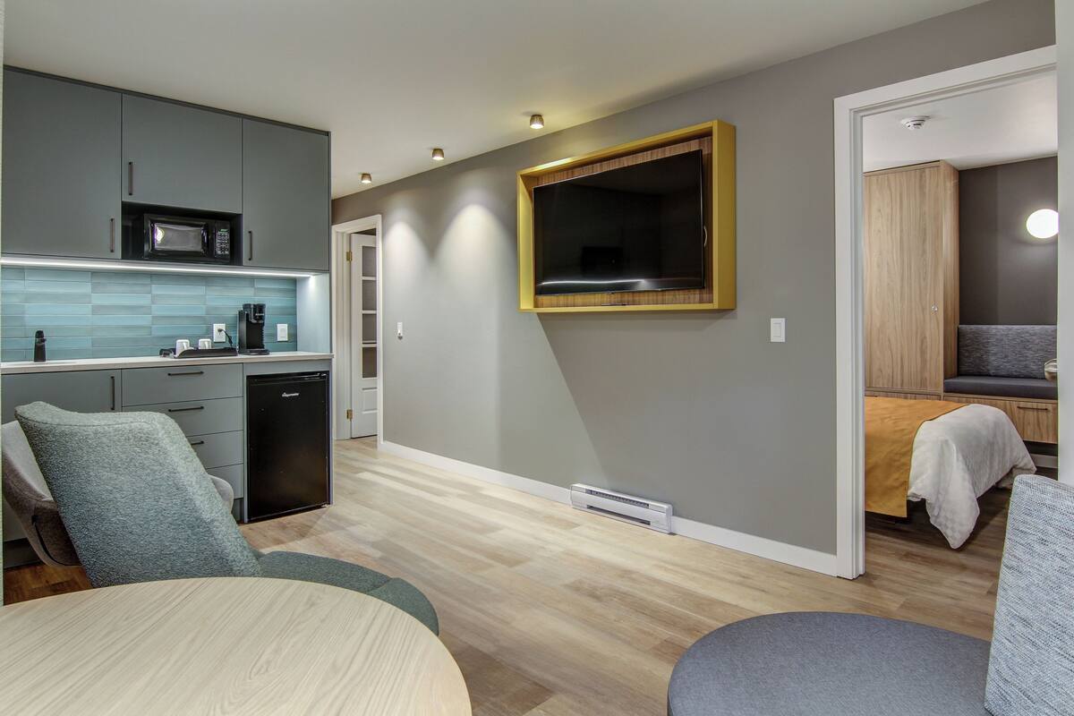 A compact living space with a kitchenette, a dining area, and a seating area.