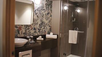 Une salle de bain avec un lavabo, un miroir et une douche.
