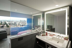 A modern bathroom with a large mirror, dual sinks, and a city view through a large window. - InterContinental Presidente Mexico City by IHG (Mexico City)