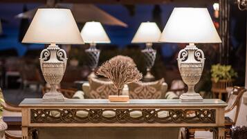 A table with three ornate lamps and a decorative centerpiece.