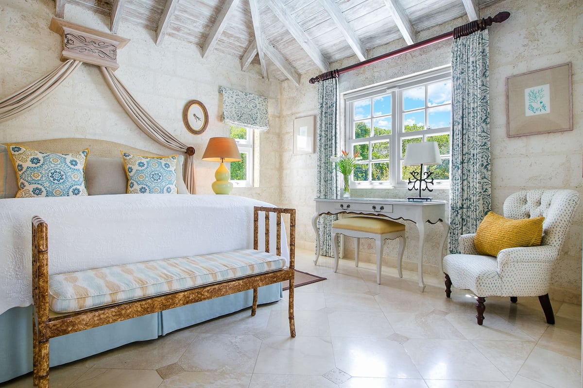 A bedroom with a bed, a desk, and a chair.