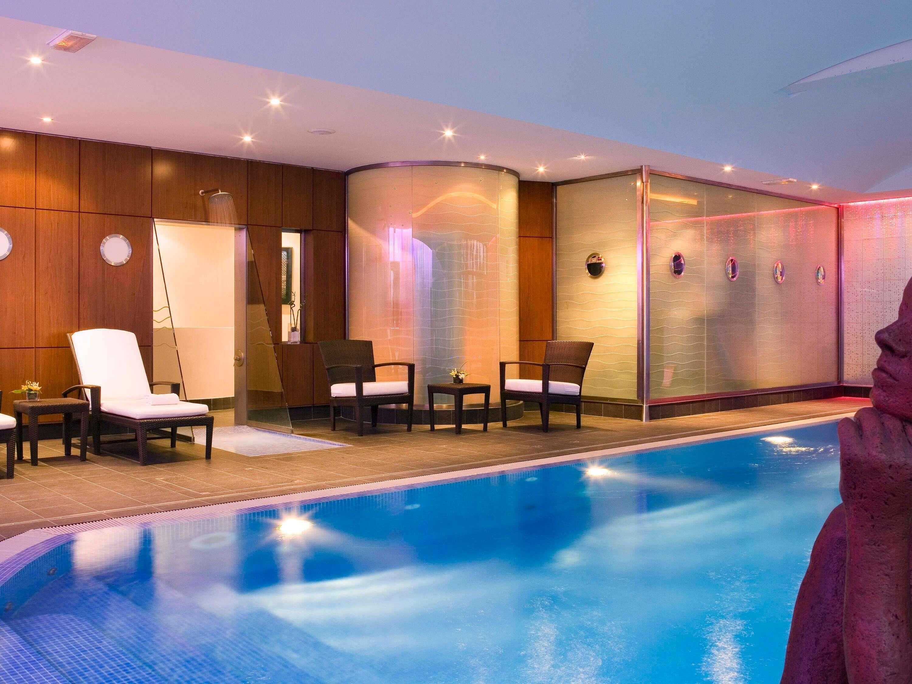 Una piscina techada, sillones reclinables de piscina