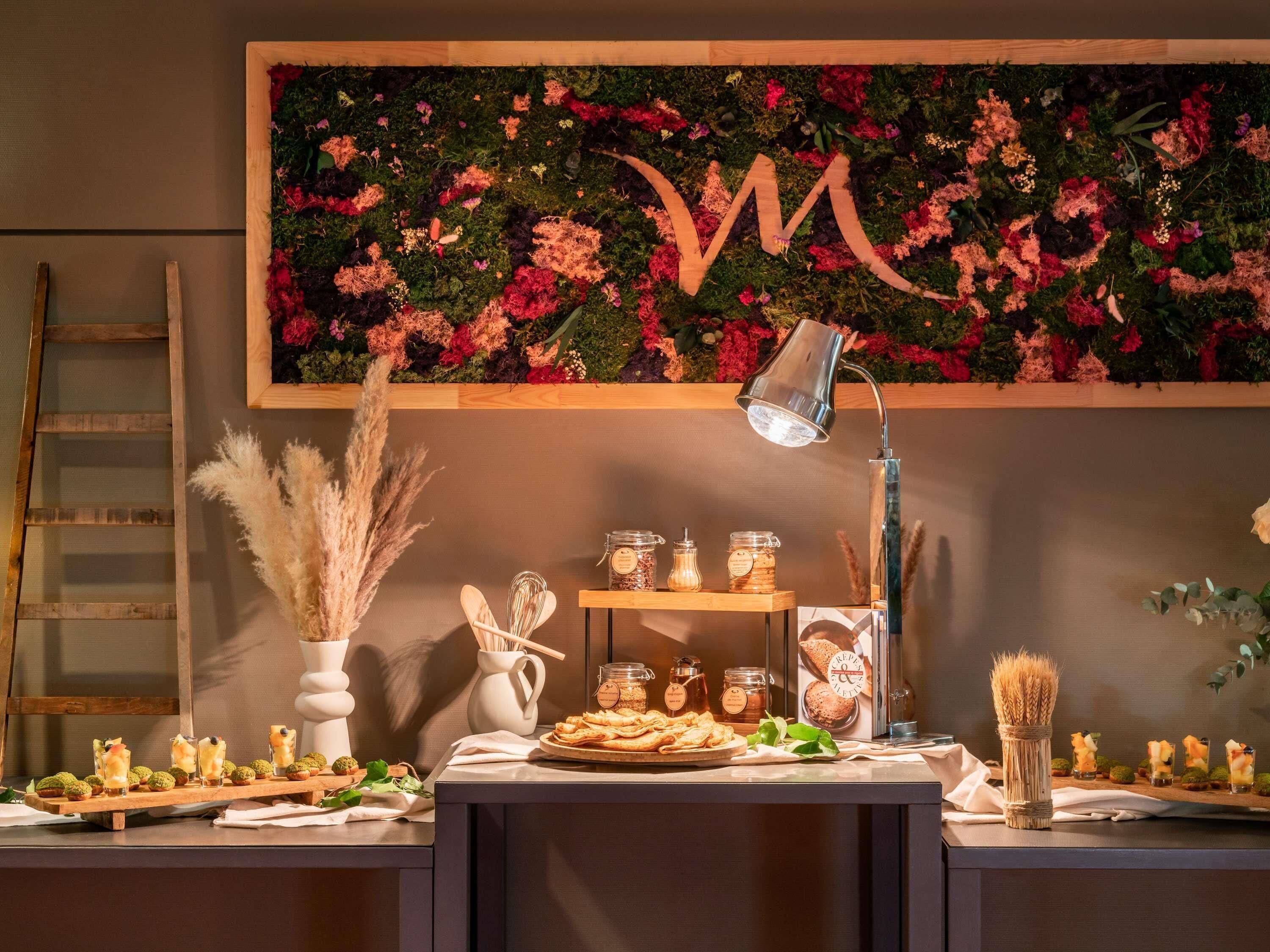 A buffet setup with a floral backdrop, a wooden ladder, and various food items.