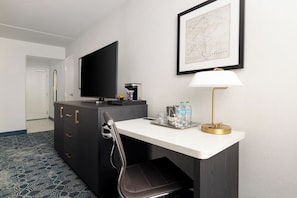 A hotel room with a desk, a chair, a television, a map on the wall, and a coffee machine. - DoubleTree by Hilton Downtown Concord (Concord)