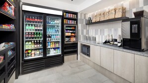 A modern kitchen with a refrigerator stocked with beverages, a microwave, and a coffee machine. - DoubleTree by Hilton Downtown Concord (Concord)